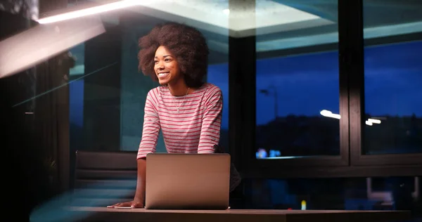 Mulher de negócios preta usando um laptop no escritório de inicialização da noite — Fotografia de Stock