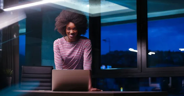 Mulher de negócios preta usando um laptop no escritório de inicialização da noite — Fotografia de Stock