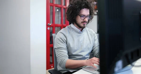 Επιχειρηματίας που εργάζεται χρησιμοποιώντας ένα φορητό υπολογιστή στο γραφείο εκκίνησης — Φωτογραφία Αρχείου