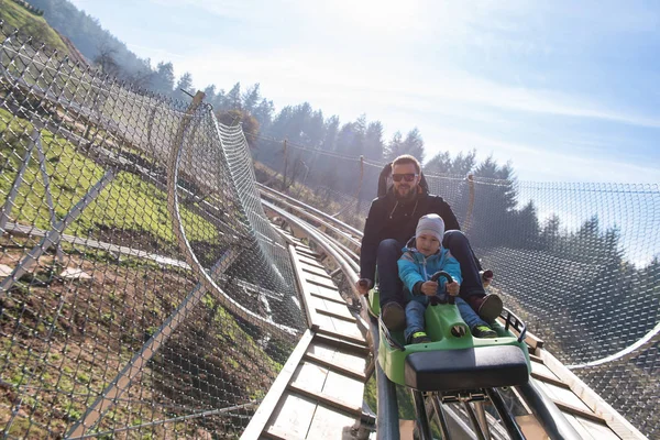 Father and son enjoys driving on alpine coaster — Stock Photo, Image