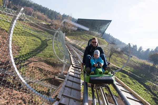 Father and son enjoys driving on alpine coaster — Stock Photo, Image