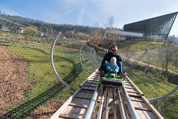 Father and son enjoys driving on alpine coaster — Stock Photo, Image