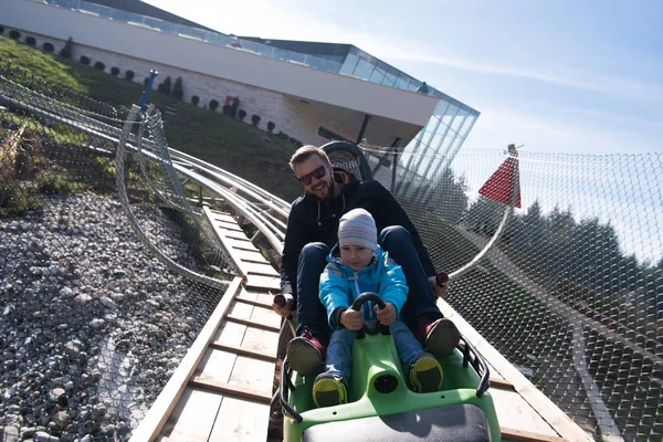 Père et fils aime conduire sur les montagnes russes alpines — Photo