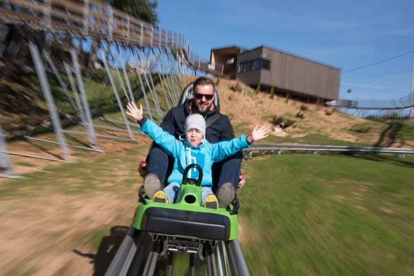 Padre e figlio si diverte a guidare sulle montagne russe — Foto Stock