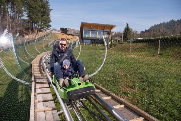 Père et fils aime conduire sur les montagnes russes alpines — Photo