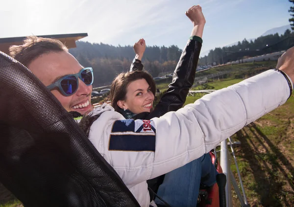 Coppia gode di guida sulle montagne russe alpine — Foto Stock