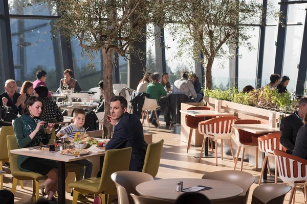 Genç ebeveynler lüks bir restoranda çocuklarıyla öğle yemeği yiyorlar.