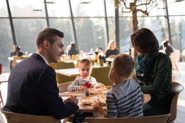 Genç ebeveynler çocuklarıyla birlikte öğle yemeği zaman zevk