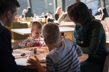 Genç ebeveynler çocuklarıyla birlikte öğle yemeği zaman zevk