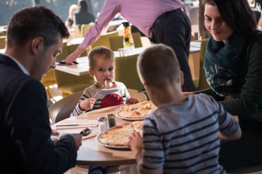 Genç ebeveynler çocuklarıyla birlikte öğle yemeği zaman zevk