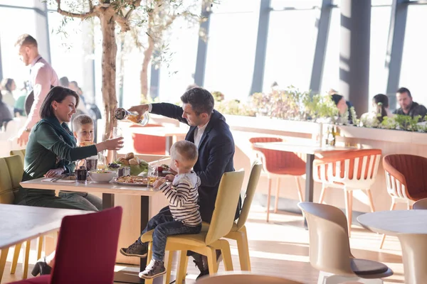 Genç ebeveynler çocuklarıyla birlikte öğle yemeği zaman zevk — Stok fotoğraf