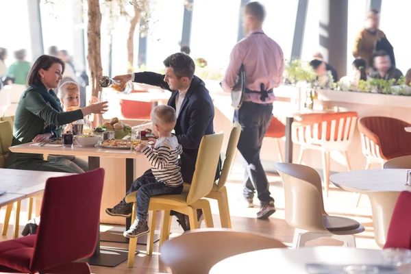 Genç ebeveynler çocuklarıyla birlikte öğle yemeği zaman zevk — Stok fotoğraf