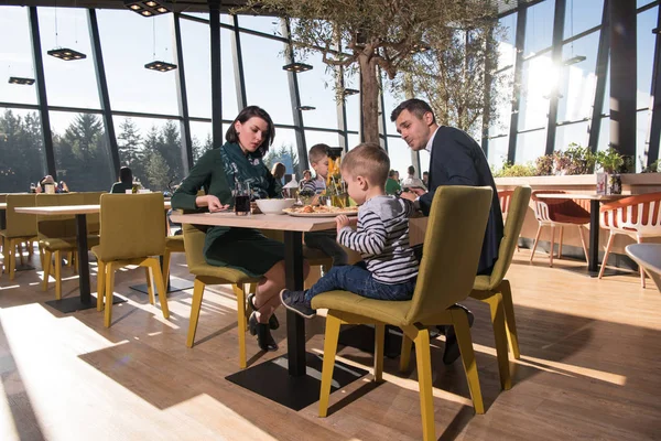 Młodzi rodzice, ciesząc się w porze lunchu z ich dzieci — Zdjęcie stockowe
