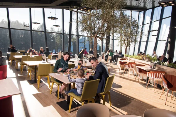 Padres jóvenes disfrutando la hora del almuerzo con sus hijos —  Fotos de Stock