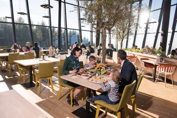 Jonge ouders genieten van lunchtijd met hun kinderen — Stockfoto