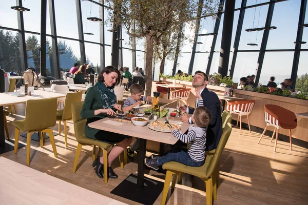 Padres jóvenes disfrutando la hora del almuerzo con sus hijos — Foto de Stock