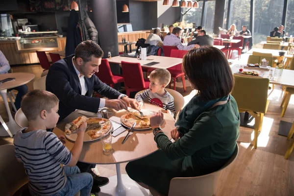 Młodzi rodzice, ciesząc się w porze lunchu z ich dzieci — Zdjęcie stockowe