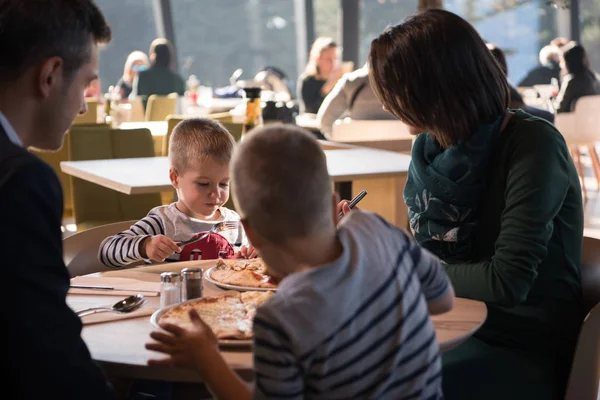 Jovens pais desfrutando do almoço com seus filhos — Fotografia de Stock