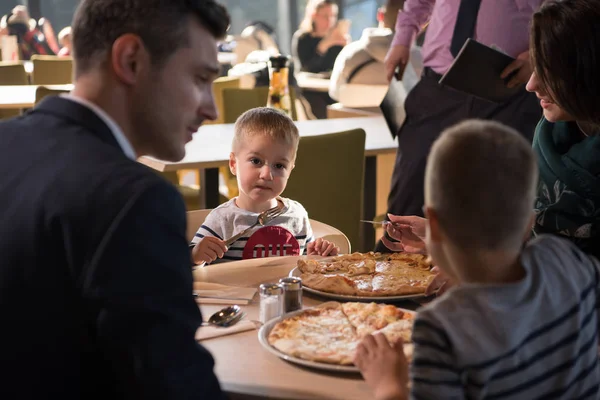 Jovens pais desfrutando do almoço com seus filhos — Fotografia de Stock