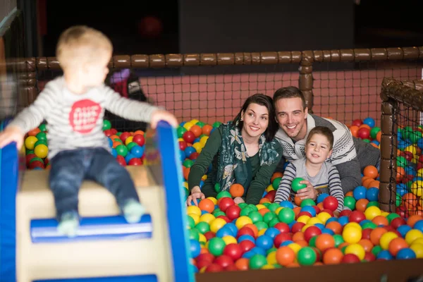 Young parents with kids in a children's playroom — Stock Photo, Image