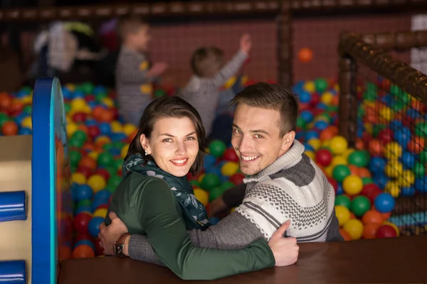 Young parents with kids in a children's playroom — Stock Photo, Image