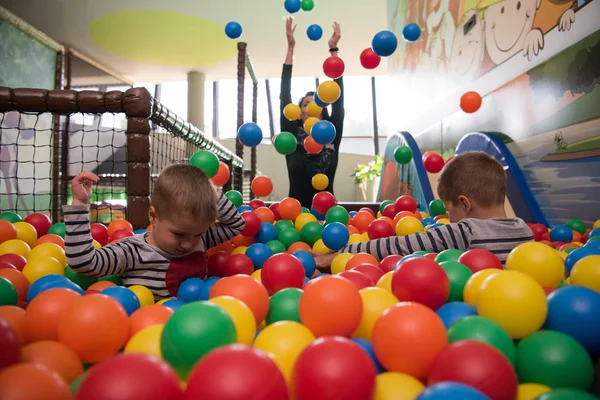 Young mom with her kids in a children's playroom — Stock Photo, Image