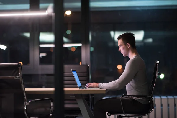 Man som arbetar på laptop i mörka office — Stockfoto