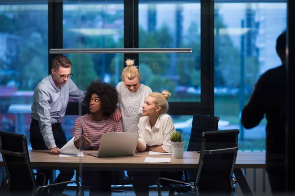 Team multietnico di start-up in ufficio notturno — Foto Stock