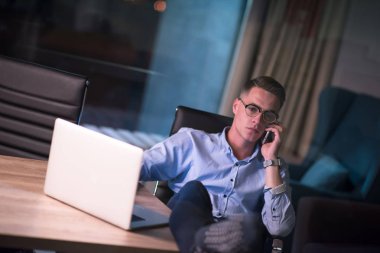 cep telefonuyla karanlık ofisinde işadamı