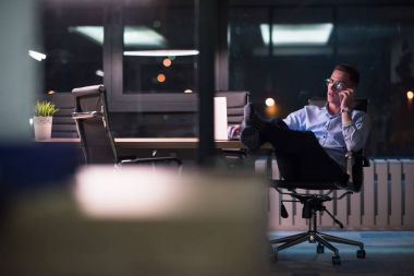 cep telefonuyla karanlık ofisinde işadamı