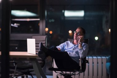 cep telefonuyla karanlık ofisinde işadamı