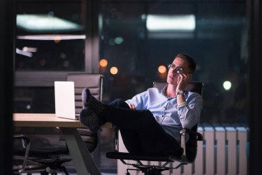 cep telefonuyla karanlık ofisinde işadamı
