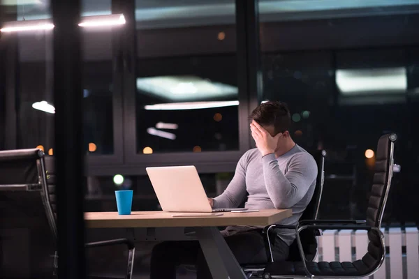 Hombre trabajando en el ordenador portátil en la oficina oscura —  Fotos de Stock