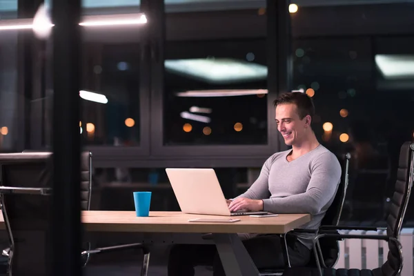 Homme travaillant sur ordinateur portable dans le bureau sombre — Photo