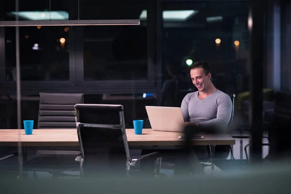 Mann arbeitet im dunklen Büro am Laptop — Stockfoto