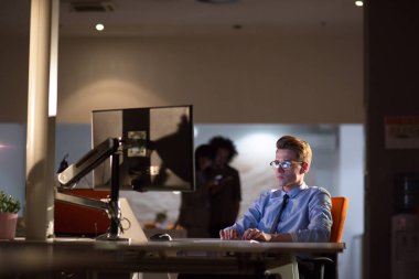 karanlık ofisinde bilgisayarda çalışan adam