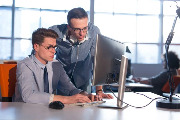 Два бизнесмена, работающие с компьютером в офисе — стоковое фото