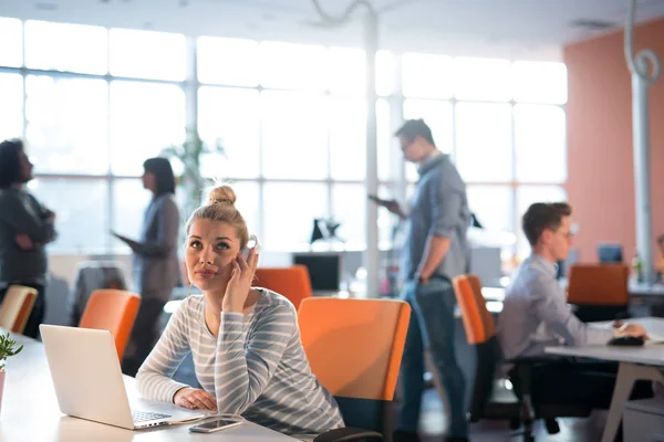 Businesswoman using a laptop in startup office — Stock Photo, Image