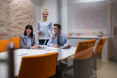 Bir grup iş adamı ofiste iş planlarını tartışıyor.