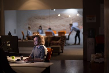 karanlık ofisinde bilgisayarda çalışan adam