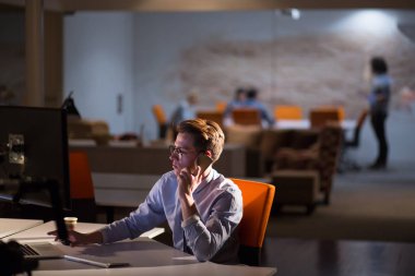 karanlık ofisinde cep telefonu kullanan adam