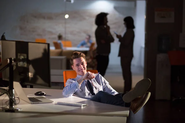 Uomo d'affari seduto con le gambe sulla scrivania in ufficio — Foto Stock