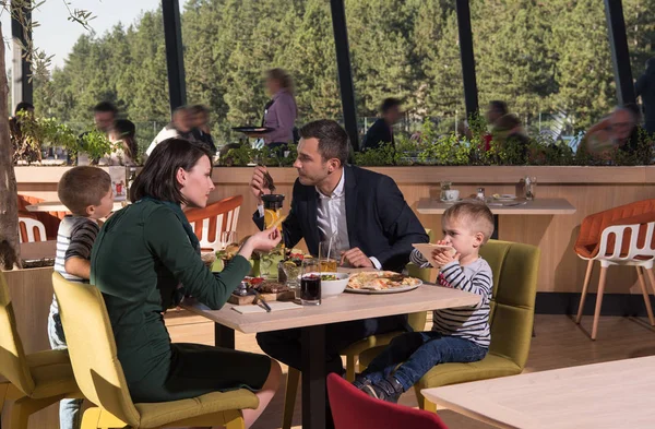 Młodzi rodzice, ciesząc się w porze lunchu z ich dzieci — Zdjęcie stockowe