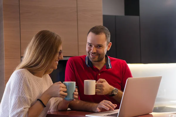 Casal beber café e usando laptop em casa — Fotografia de Stock