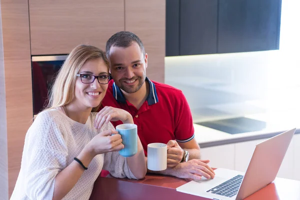 Pareja beber café y el uso de la computadora portátil en casa — Foto de Stock