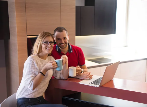 Пара п'є каву і використовує ноутбук вдома — стокове фото