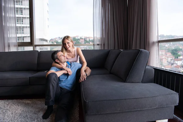 Young handsome couple hugging on the sofa — Stock Photo, Image
