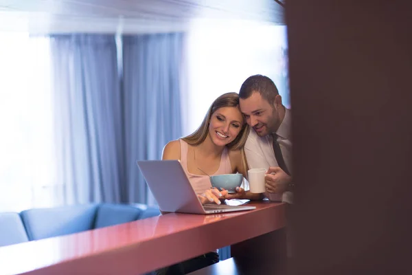Una pareja joven se está preparando para un trabajo y usando una computadora portátil —  Fotos de Stock