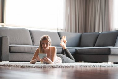 tablet bilgisayar yere kullanan genç kadın