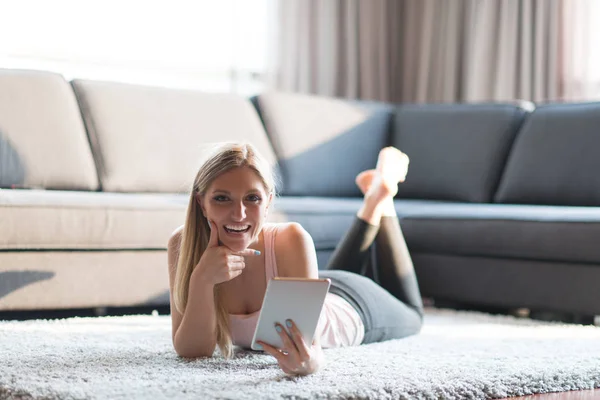 Young woman using tablet computer on the floor — Stock Photo, Image